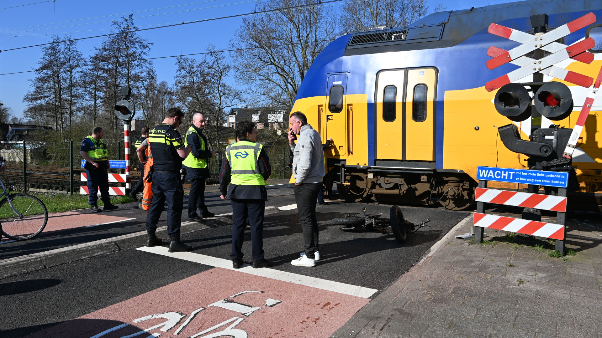 Foto: spoorpolitie en trein op overweg met afgebroken slagboom.JPG